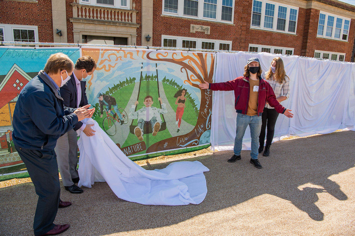 Mayor David Meyer, Enrico Cecchi, student Austin Eilbert and Mrs. PJ Naber unveiling Austin Eilbert's piece, "#Nature."