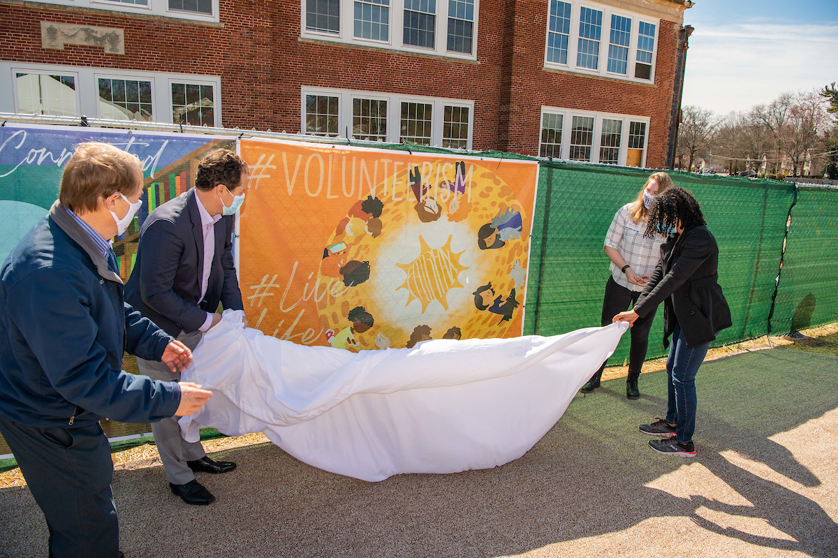 Mayor David Meyer, Enrico Cecchi, student Rocket Beeson and Mrs. PJ Naber unveiling Rocket Beeson's piece, "#Volunteering."